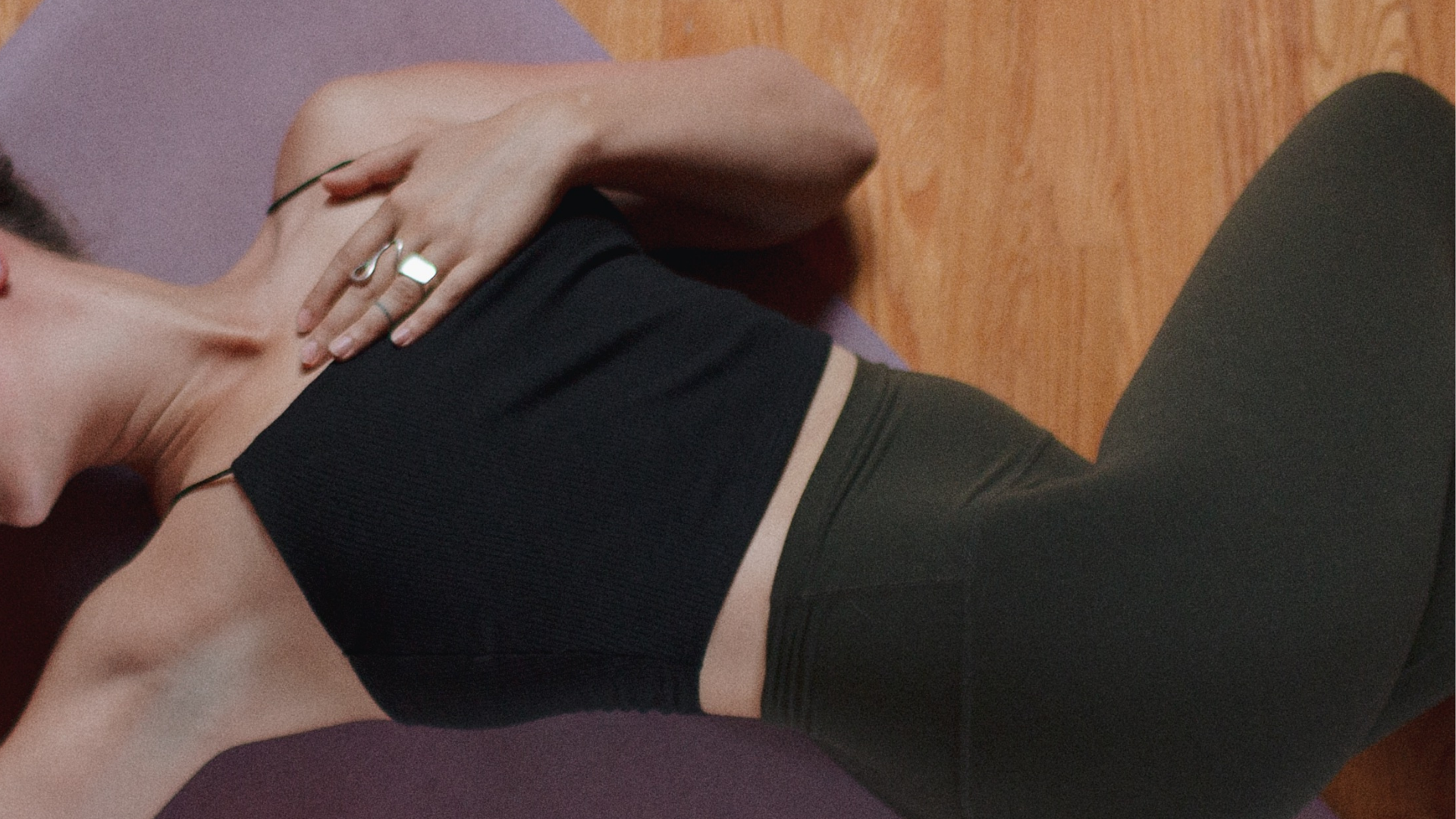 Naomi Elder in downward dog yoga pose, with one leg in the air