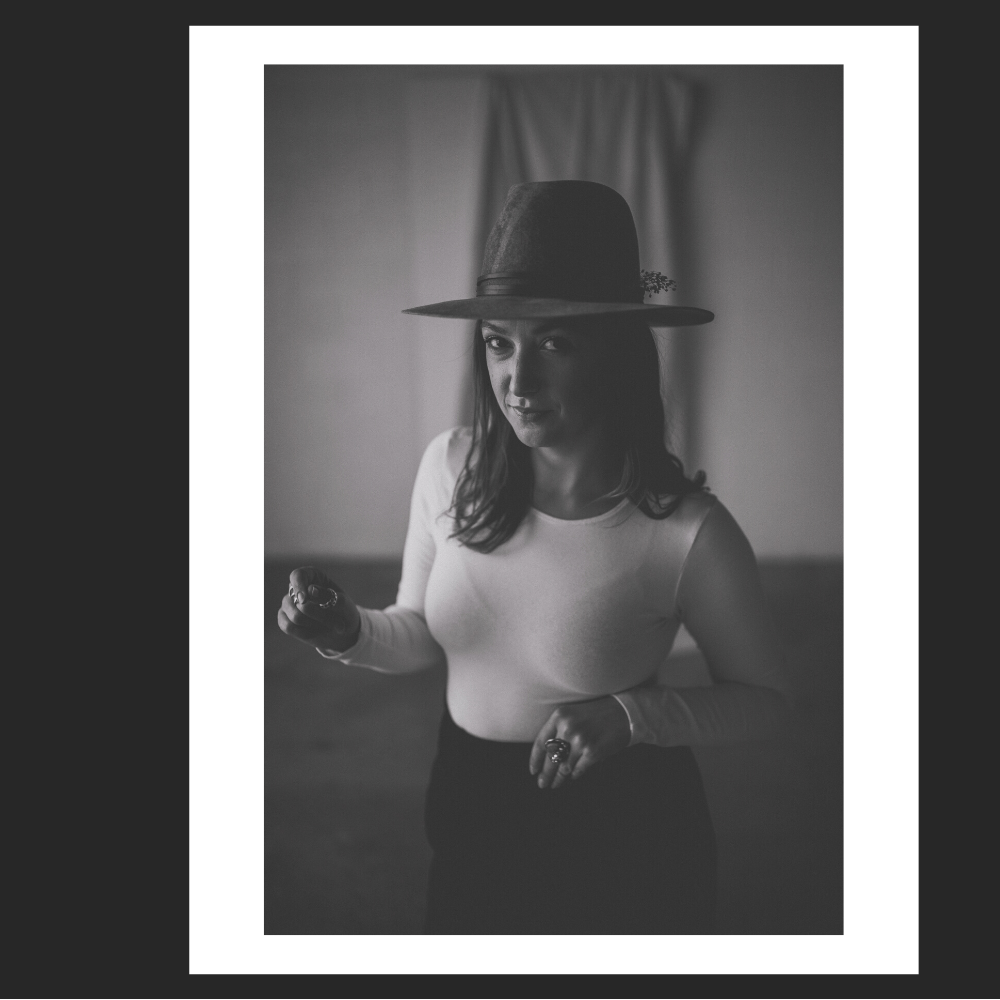 Coach Naomi Elder black and white portrait of woman wearing a hat